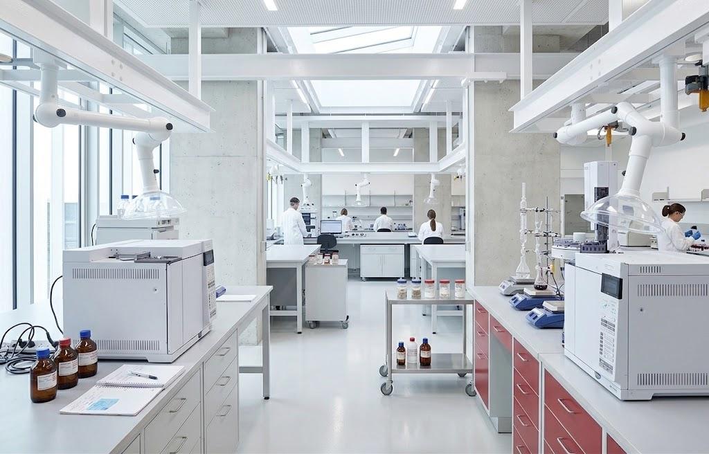 Laboratorio con bracci aspiranti installati su binari a soffitto sopra le postazioni di lavoro